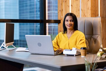 Businesswoman using laptop while sitting in office