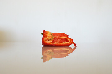 one cut red paprika on a white table