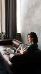 Naklejka premium Productive Home Workspace: Young Woman Working on Laptop, Illustrating the Concept of Work or Study from Home, Freelancing, Business, and Modern Lifestyle for Students and Professionals