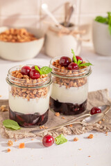 Sweet and tasty cherries granola with oat flakes in jar.