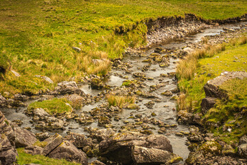 river through rocks and green grass