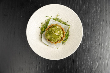 Pistachio dessert served on a white plate, top view
