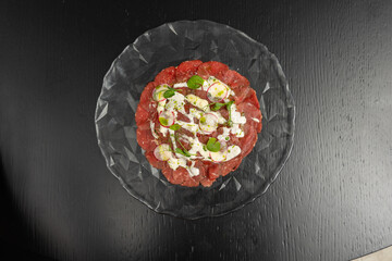 Beef carpaccio on a plate on a table
