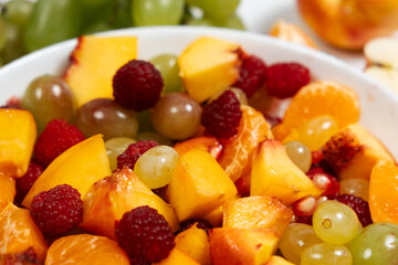 A healthy dessert is a fruit salad made from mixed raspberries, tangerines, grapes and nectarines.