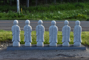 The small stone buddha statues showing their backs on the drive way near the Takino Reien in Sapporo Japan