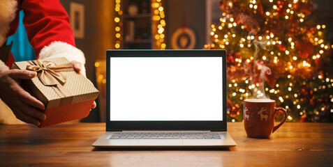 Santa Claus bringing a gift and blank laptop
