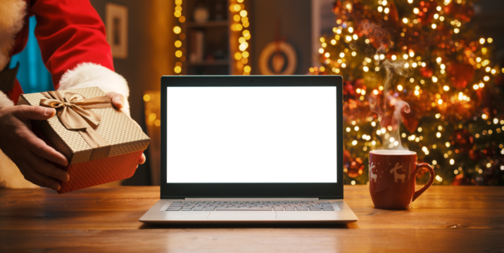 Santa Claus bringing a gift and blank laptop