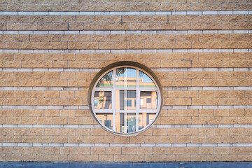 Urban architecure. Stone wall with round window.