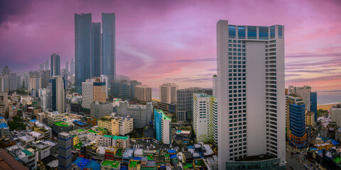 Busan City panorama of the skyline, modern and rustic buildings with dramatic beautiful sunset and cloudscape over the Haeundae Beach ocean view in Kyongsang Namdo, South Korea - obrazy, fototapety, plakaty