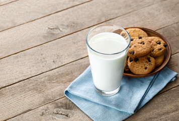 milk in glass and chocolate chip cookies on plate on table