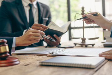 Businessman and team discuss with lawyer about contract documents to ensure correctness and...