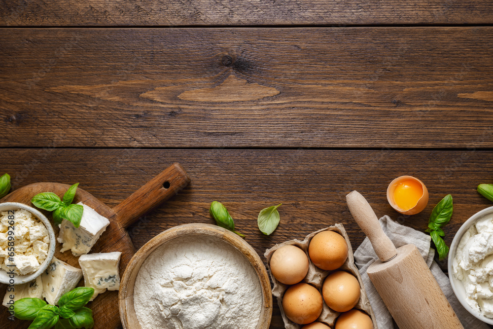 Aufkleber set of raw ingredients for cooking italian ravioli with various cheeses and spinach on a wooden tabl