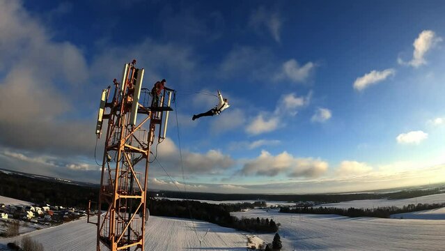 jump from a height, jump from a tower with belay, a girl jumps from a height with belay, a woman jumps from a tower with belay, 
Slow motion