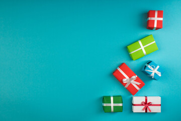 Obraz premium Gift boxes and colorful present for christmas on blue background. Top view with copy space.