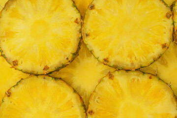 Pineapple juicy yellow slices as a background.