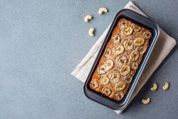 Delicious freshly baked homemade banana bread cake with no gluten and sugar free, top view on gray concrete background, flat lay style. Healthy sweet food. Negative space for text.