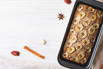 Delicious freshly baked homemade banana bread cake with no gluten and sugar free, top view on white wooden background, flat lay style. Healthy sweet food. Negative space for text.
