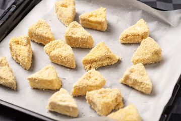 Recipe for fried camembert cheese. Triangular slices of cheese in breadcrumbs
