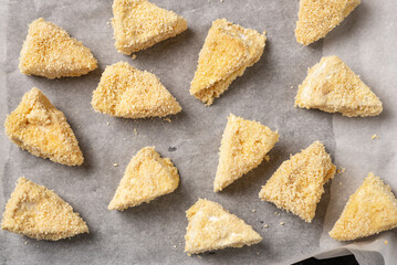 Slices of cheese wrapped in breadcrumbs, preparation for frying