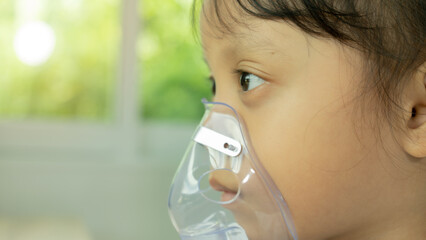 Sick child inhaling with inhaler, child making inhaler at home Oxygen therapy spray Stuffy nose and allergies health medicine