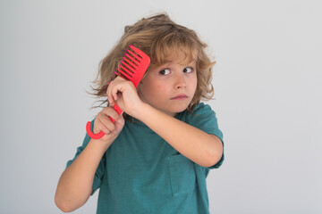 Comb and hair brush concept. Kid brushing tangled hair. Funny kids haircut.