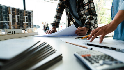 Obraz premium Two engineer working to discuss and brainstorming about blueprint of construction project in office