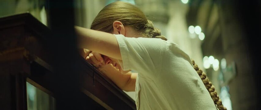 Woman praying in the church on her knees. Forgiveness of God and believe in goodness. Christian life crisis prayer.