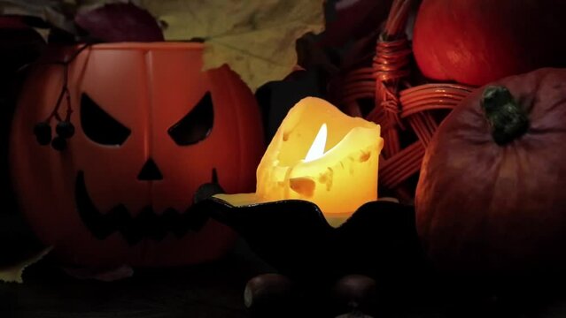 Happy Halloween. A plastic pumpkin bucket with an evil smiling. Halloween horror concept. Ripe pumpkins in a basket in the light of a candle, horror concept, Halloween holiday
