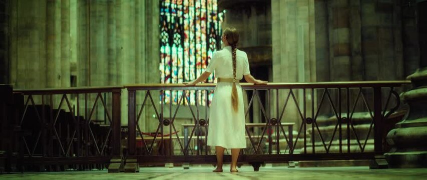 Barefoot woman wanderer looking for God in church. Adult girl with braided hair in a long dress in the Temple.
