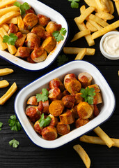 Traditional German currywurst, served with potato chips and sauce