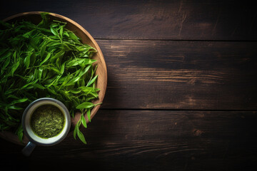 Fresh green tea with tea leaves on a dark wooden background, top view, copy space