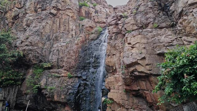 A beautiful view of a cascading holy waterfall from the top of the mountain