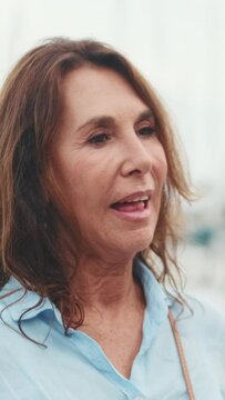 Close-up of beautiful elderly woman standing in the port and talking with somebody