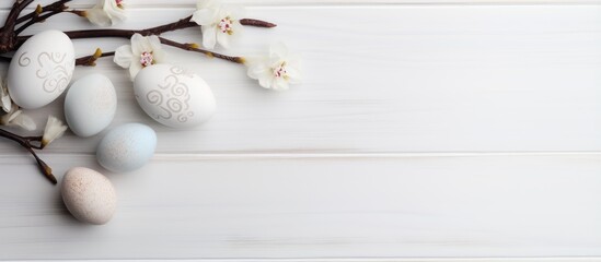 Easter themed branch with eggs on white wood background
