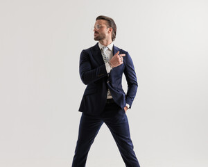 confident businessman with glasses looking to side and holding hand in pocket
