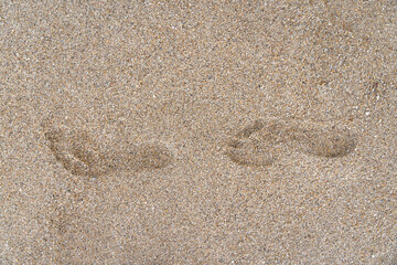 Fototapeta na wymiar close-up shot of human footstep on the sandy beach. Minimalistic. Conceptualizes solitude, travel, the footprint of humanity on the planet's destiny, psychology, and finding solace in nature alone