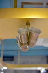 Metal cups hanging from cabinets