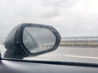 raindrops on side mirror and window on a car