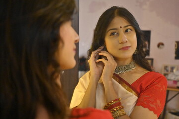 Woman getting ready infront of the mirror. Indian woman watching on mirror. Traditional look. Saree and jewellery. Maharashtra. Beautiful Bride