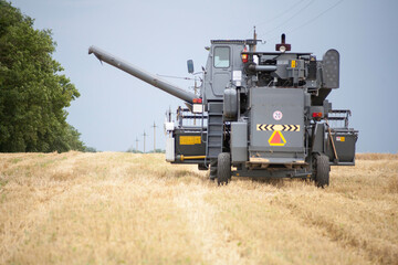 Fototapeta premium Old Russian grain harvester combine in the field. Russian combine harvester 