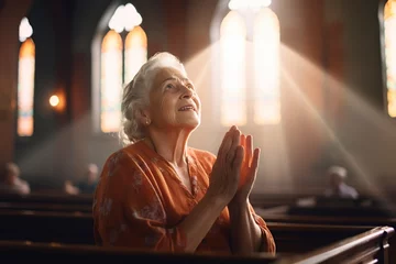 Selbstklebende Fototapeten old woman in the church saying a prayer for the holy spirit © Jorge Ferreiro