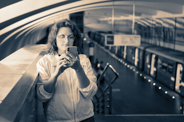 Fototapeta premium Adult woman using mobile phone at subway station in Moscow, Russia.