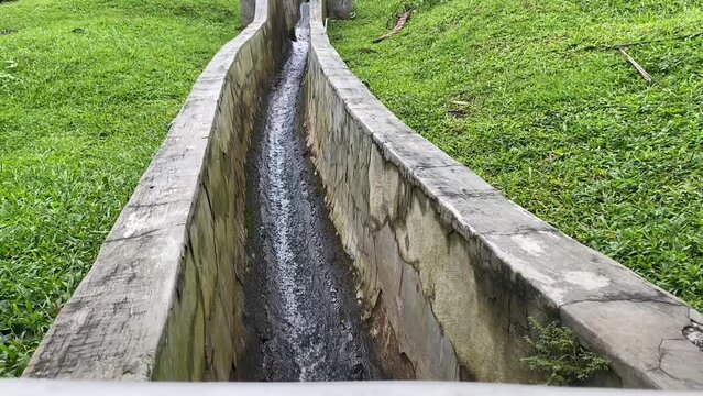 swift water flow ditches at greenery grass.