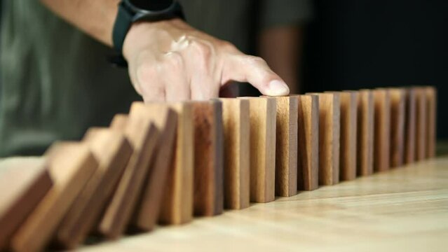 Domino Effect, Inflation Financial Crisis. Business leader hand stopping wooden domino protect crisis effect. Concept of Risk, Assessment, Insurance, Security, Financial, Recession, Business