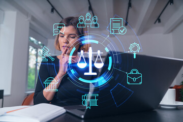 Pensive attractive beautiful businesswoman in formal wear working on laptop at office workplace in background. flying legal icons. Notebook on the table. Concept of law and order.