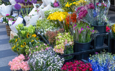 Bouquets of various flowers are sold in a flower shop.