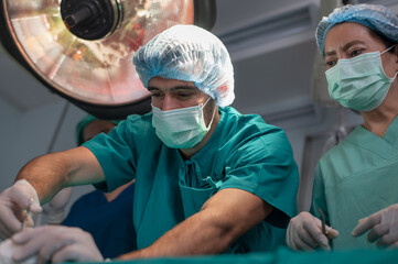 Team of professional doctors performing operation in surgery room