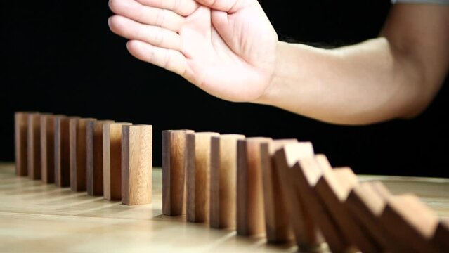 Inflation Financial Crisis, Recession, Business Risk Management Concept. Businessman hand stopping wooden domino protect crisis effect. Concept of Risk, Assessment, Insurance, Security, Financial