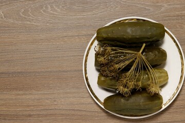 Close-up on top of pickles on a platter with dill umbel. - obrazy, fototapety, plakaty
