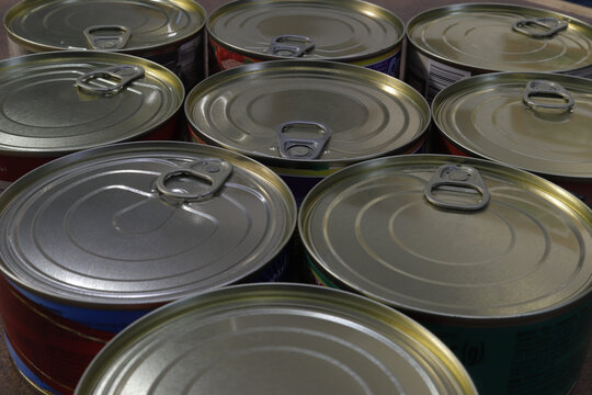 Close-up of a group of closed tin cans with a key to open them.